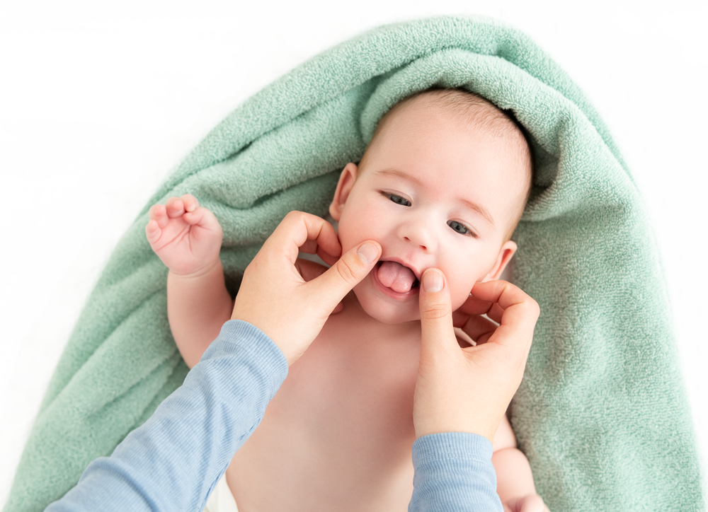 Baby erhält Gesichtsmassage